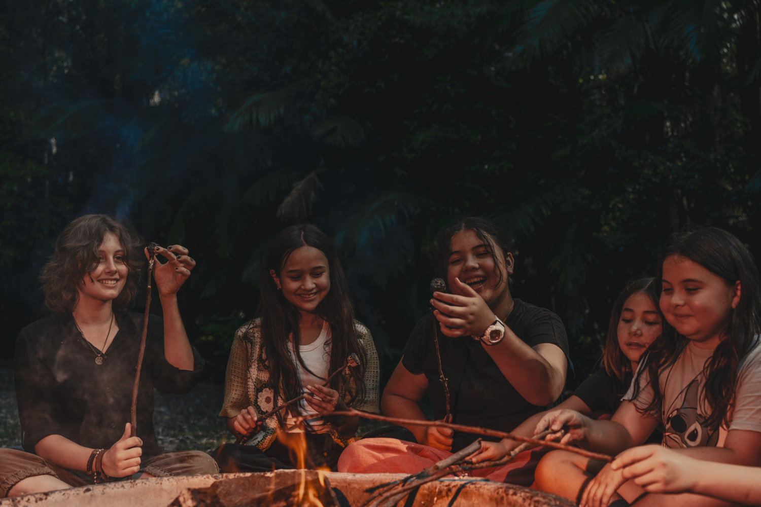 Children toasting marshmallows around the campfire